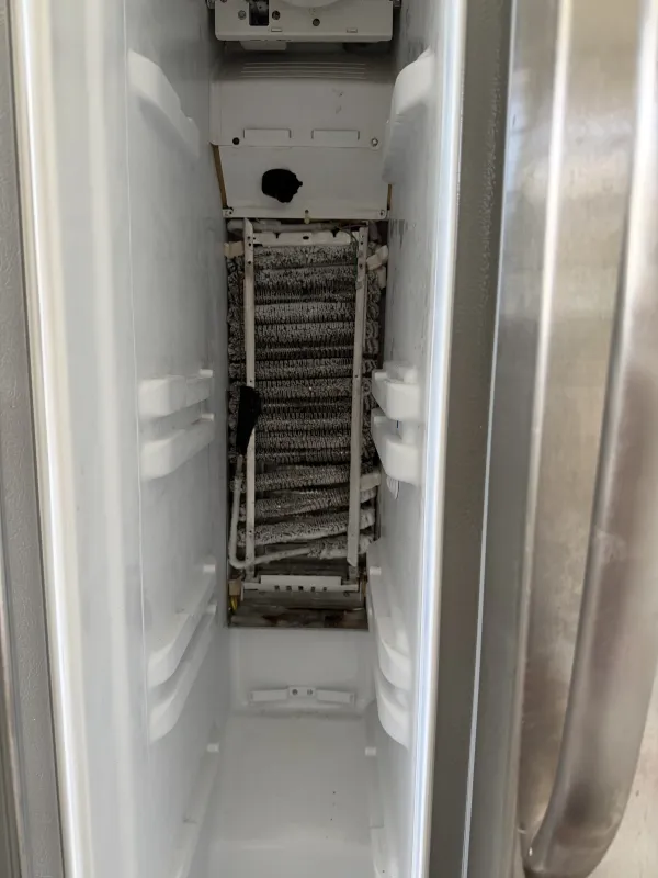 Frost-covered refrigerator evaporator found during appliance repair diagnosis