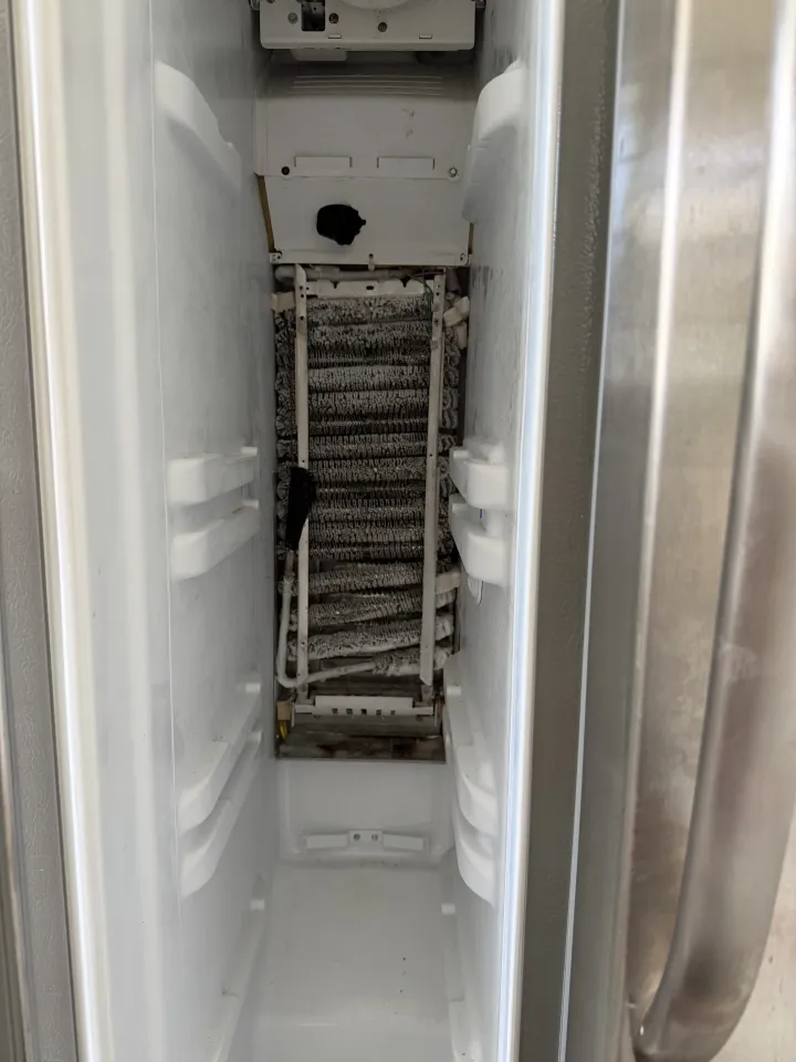 Refrigerator evaporator coil covered in frost before repair service