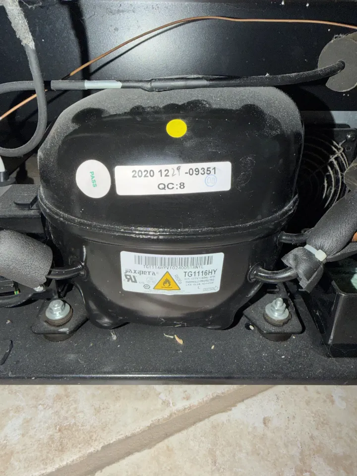 Refrigerator compressor inspected during a no-cooling diagnosis
