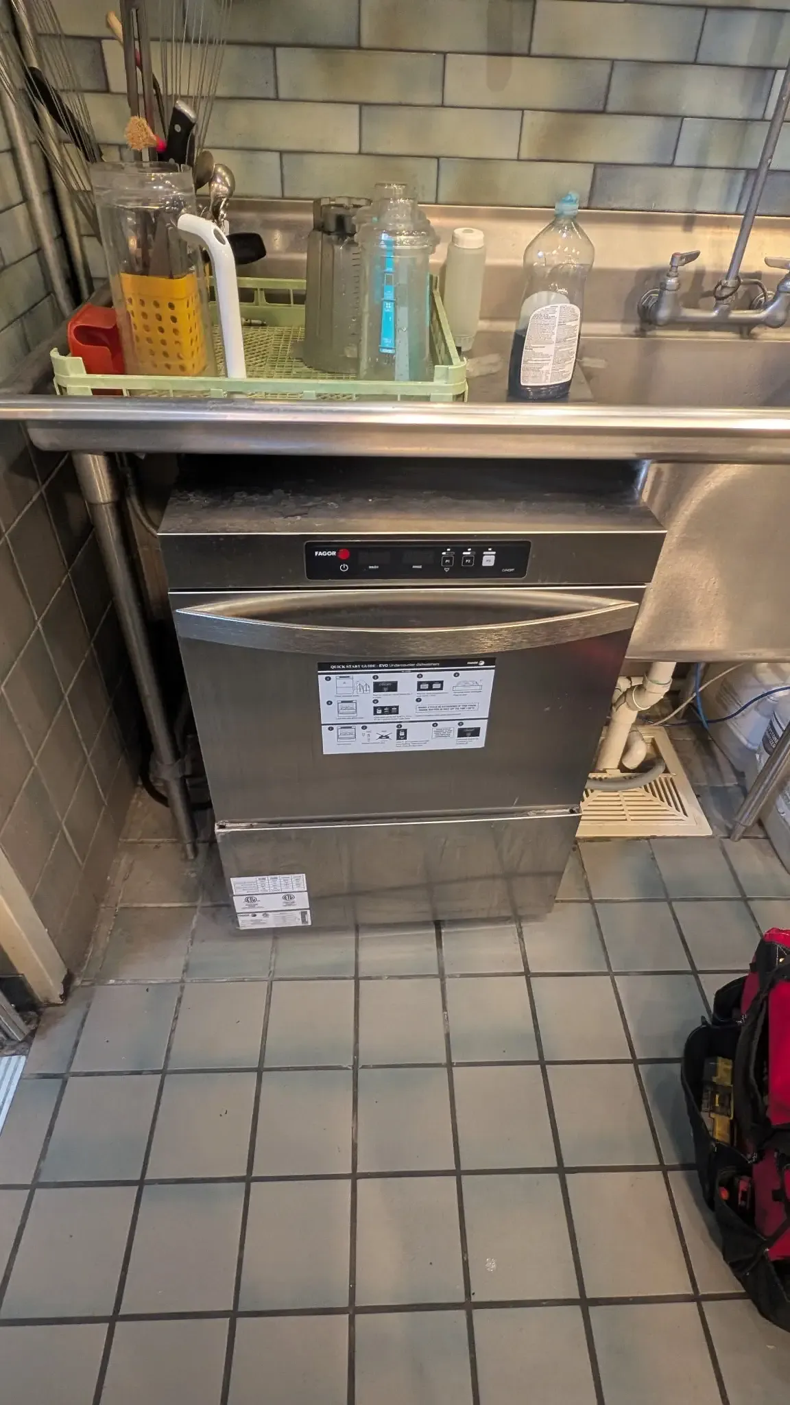 Commercial imperial dishwasher under repair in commercial kitchen